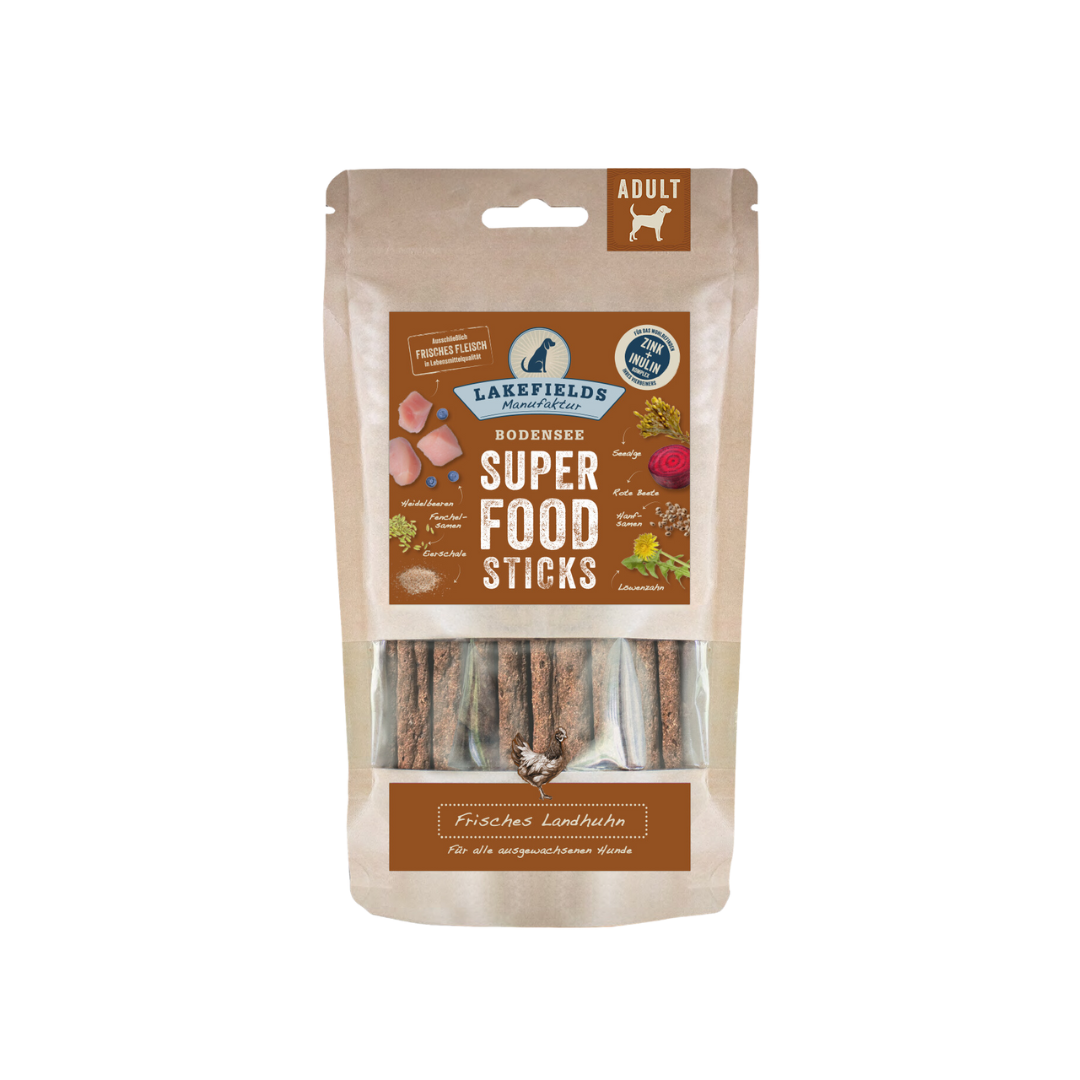 Verpackung von Lakefields Superfood Sticks, 130g. Die Tüte zeigt verschiedene Zutaten wie Gemüse und Fleisch, mit einem Hundesymbol.