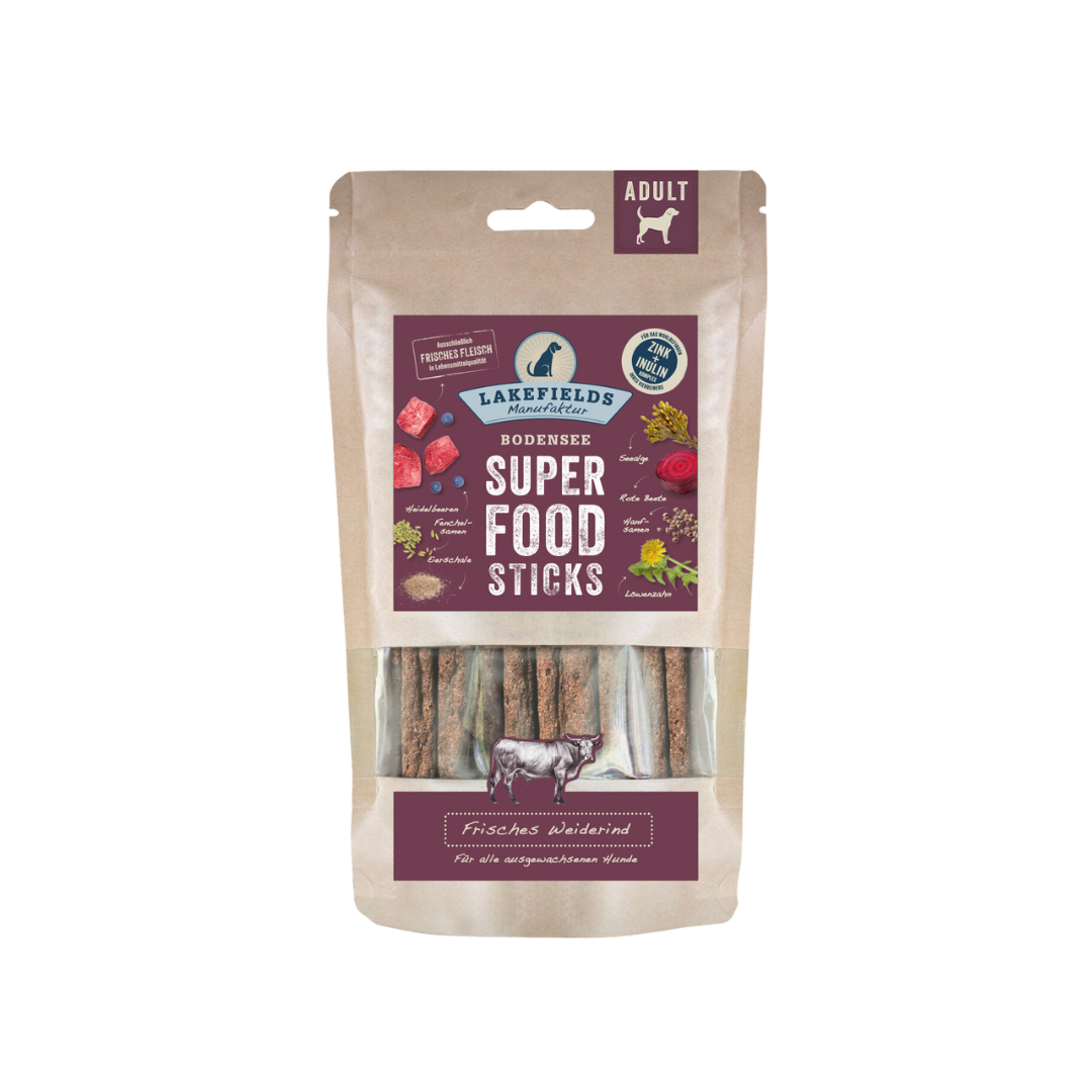 Verpackung von Lakefields Superfood Sticks, 130g. Die Tüte zeigt verschiedene Zutaten wie Gemüse und Fleisch, mit einem Hundesymbol.