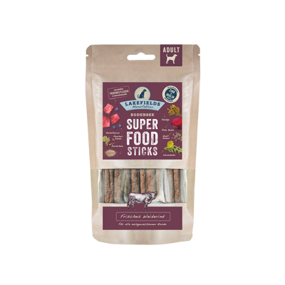 Verpackung von Lakefields Superfood Sticks, 130g. Die Tüte zeigt verschiedene Zutaten wie Gemüse und Fleisch, mit einem Hundesymbol.