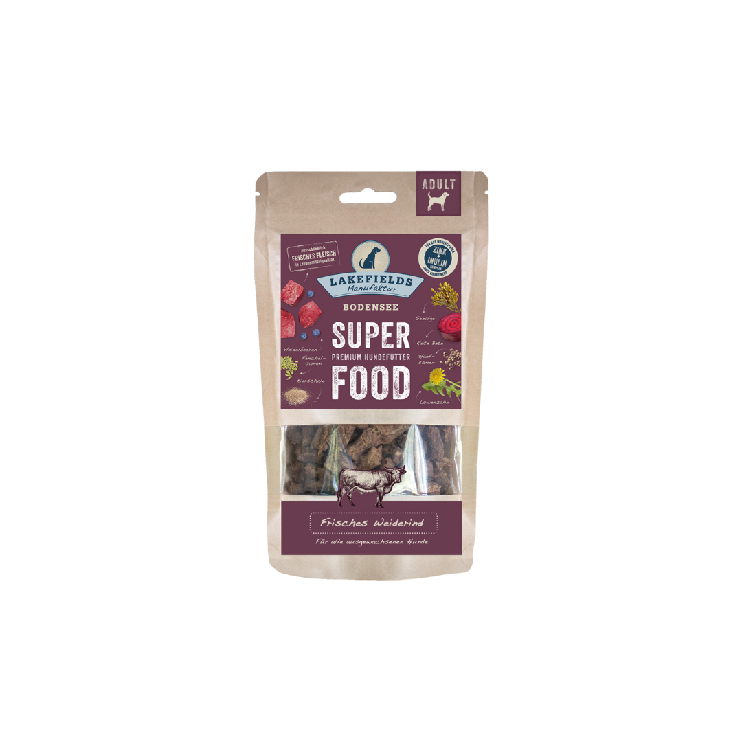 Verpackung von Lakefields Superfood für Hunde, 130g. Violette Tüte mit Bildern von Weiderind, Kräutern und dem Text 'Adult'.