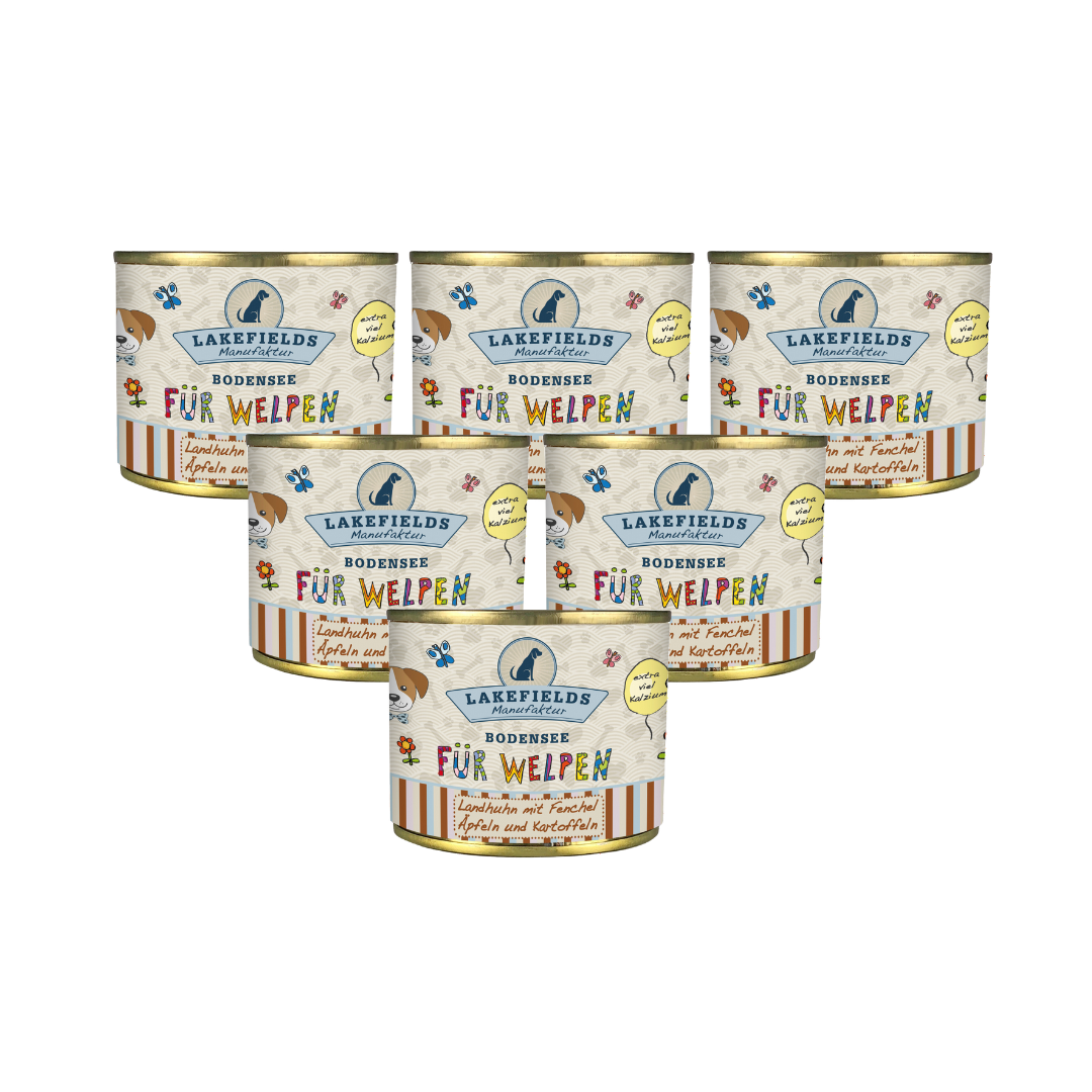Sechs runde Dosen mit Hundefutter von Lakefields, 200g. Auf dem Etikett steht 'BODENSEE FÜR WELPEN', mit Abbildungen von Hunden, Blumen und Texten.