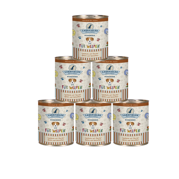 Sechs runde Dosen mit Hundefutter von Lakefields, 800g. Auf dem Etikett steht 'BODENSEE FÜR WELPEN', mit Abbildungen von Hunden, Blumen und Texten.
