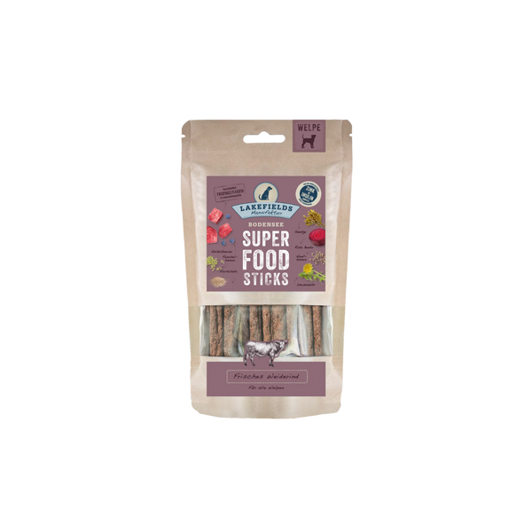 Verpackung von Lakefields Superfood Sticks für Welpen, 130g. Die Tüte zeigt verschiedene Zutaten wie Gemüse und Fleisch, mit einem Hundesymbol.