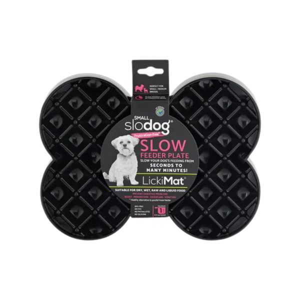 Schwarze Futterplatte 'LickiMat Slodog' in Form eines Knochens mit rautenförmigen Vertiefungen. Verpackung zeigt einen Hund und Informationen zur Verwendung.