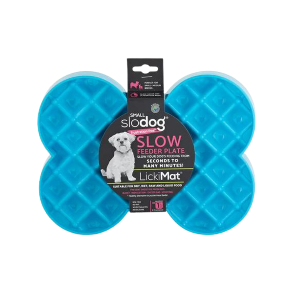 Türkise Futterplatte 'LickiMat Slodog' in Form eines Knochens mit rautenförmigen Vertiefungen. Verpackung zeigt einen Hund und Informationen zur Verwendung.