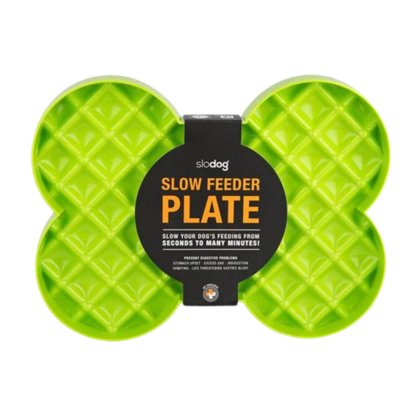 Grüne Futterplatte 'LickiMat Slodog' in Form eines Knochens mit rautenförmigen Vertiefungen. Verpackung zeigt einen Hund und Informationen zur Verwendung.