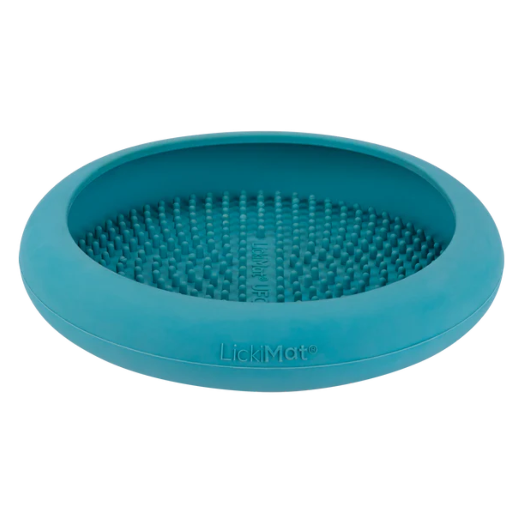 Runde, flache Futterbox in Blau mit einer strukturierten Oberfläche aus kleinen Noppen. Auf der Unterseite steht 'LickiMat®'.