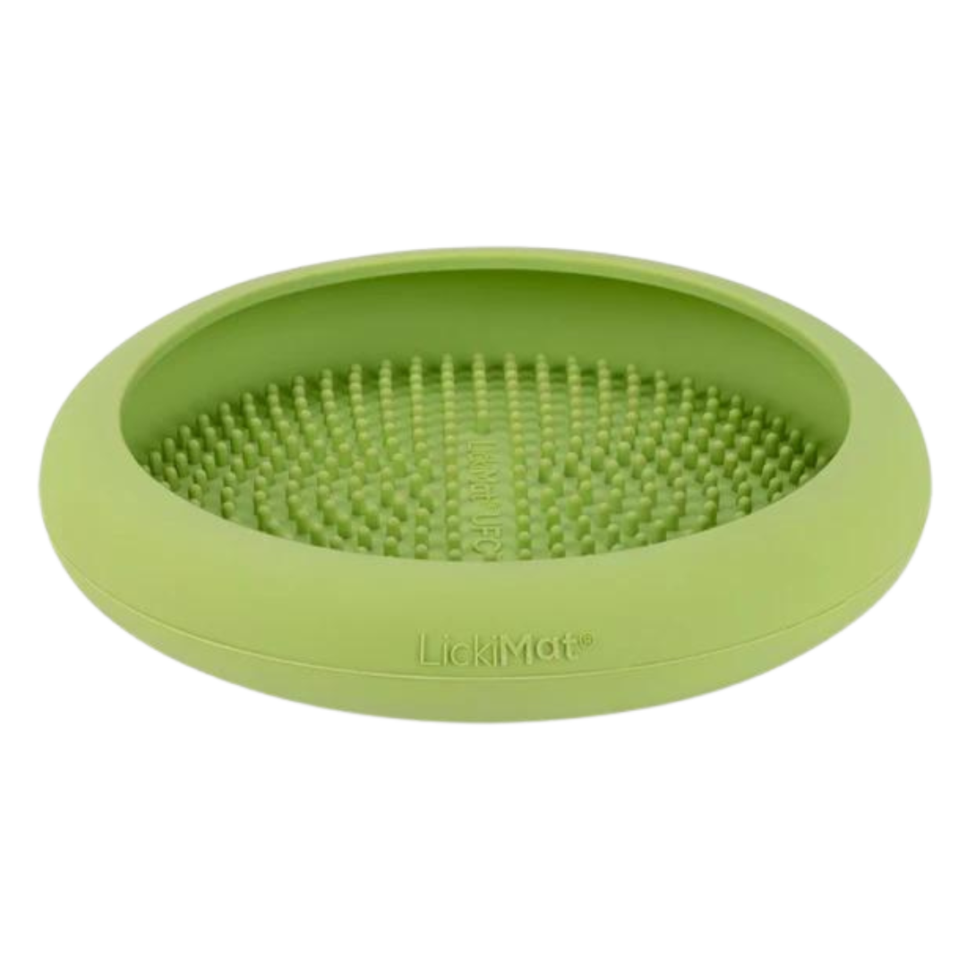Runde, flache Futterbox in Grün mit einer strukturierten Oberfläche aus kleinen Noppen. Auf der Unterseite steht 'LickiMat®'.