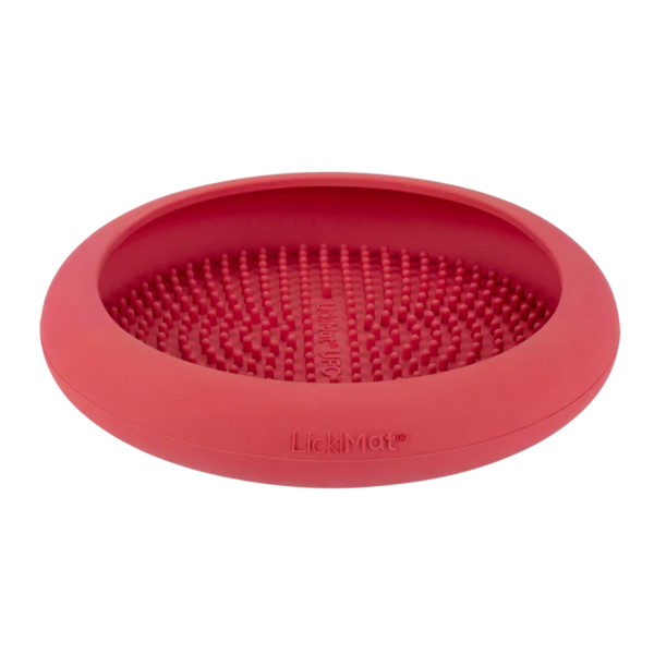 Runde, flache Futterbox in Pink mit einer strukturierten Oberfläche aus kleinen Noppen. Auf der Unterseite steht 'LickiMat®'.