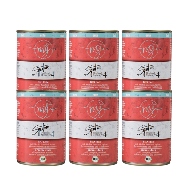 Sechs Dosen für Hundefutter mit rotem Etikett. Aufschrift: my Signature, Dogfood Menue No. 4, BIO Ente und Zutaten wie Kürbis, Zucchini, Spinat, Johannisbeere und Heidelbeere.