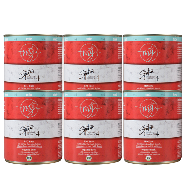 Sechs Dosen für Hundefutter mit rotem Etikett. Aufschrift: my Signature, Dogfood Menue No. 4, BIO Ente und Zutaten wie Kürbis, Zucchini, Spinat, Johannisbeere und Heidelbeere.