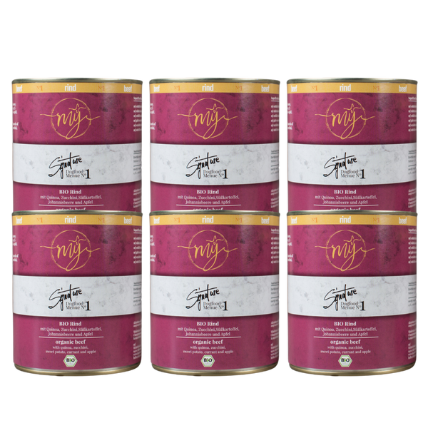 Sechs Dosen Hundefutter mit pinkem Etikett. Aufschrift: my Signature, Dogfood Menue No. 1, BIO Rins und Zutaten wie Quinoa, Zucchini, Süßkartoffeln, Johannsibeeren, Apfel