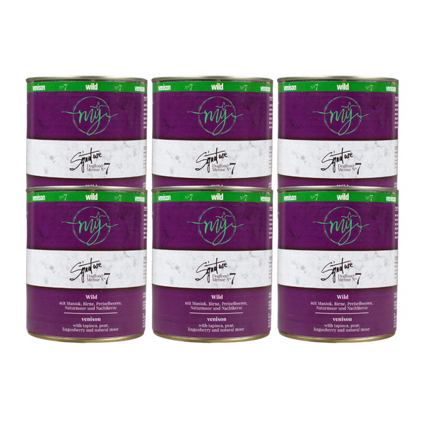 Sechs Dosen Hundefutter mit dunklem violetten Etikett. Aufschrift: my Signature, Dogfood Menue No.7, Wild und Zutaten wie Maniok, Birnen, Preiselbeeren, Naturmoor, Nachtkerze
