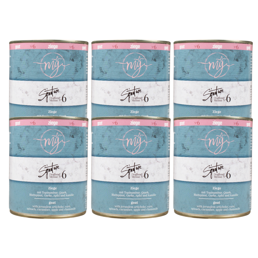 Sechs Dosen Hundefutter mit hell blauem Etikett. Aufschrift: my Signature, Dogfood Menue No.6, Ziege und Zutaten wie Topinambur, Quark, Blattspinat, Gurke, Apfel