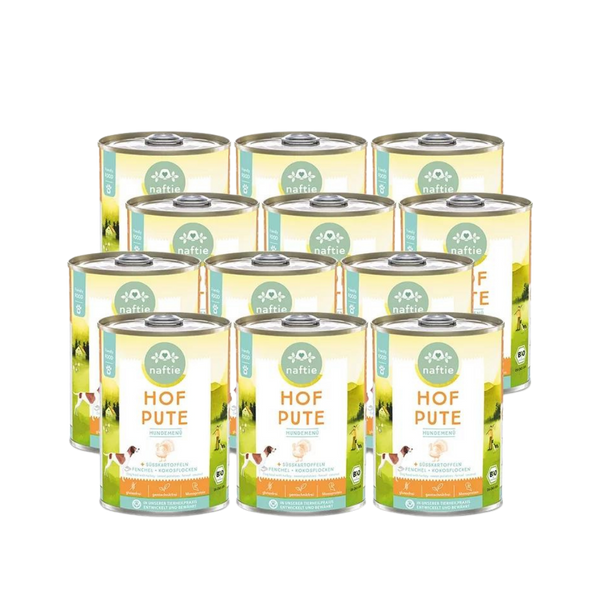Zwölf Dosen mit Bio-Hundefutter von naftie, 400g, mit Abbildung eines Hundes und Landschaft im Hintergrund. Aufschrift: 'HOF PUTE HUNDEMENÜ.