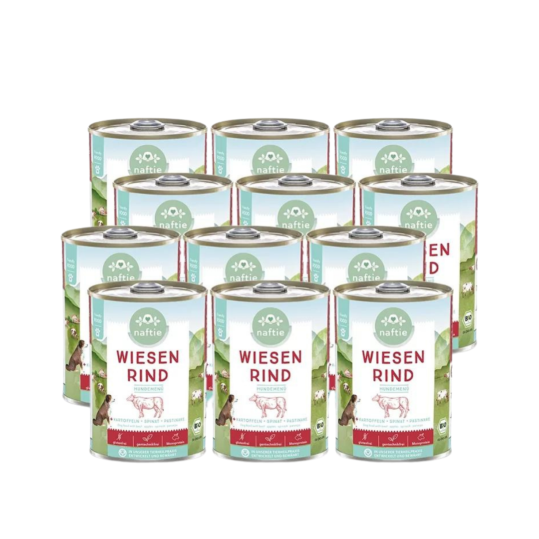 Zwölf Dosen mit Bio-Hundefutter von naftie, 400g, mit Abbildung eines Hundes und Landschaft im Hintergrund. Aufschrift: 'WIESEN RIND HUNDEMENÜ.