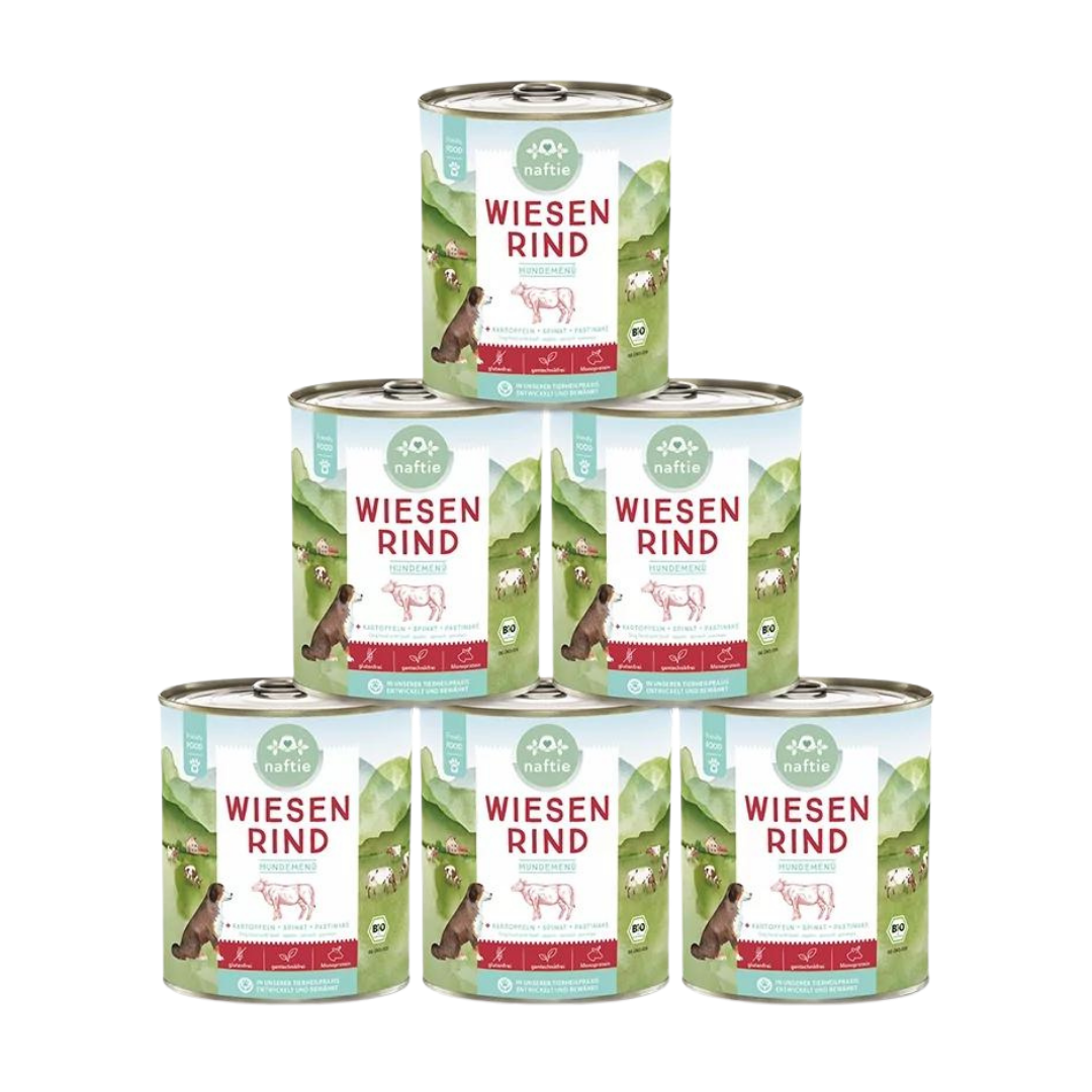Sechs Dosen mit Bio-Hundefutter von naftie, 800g, mit Abbildung eines Hundes und Landschaft im Hintergrund. Aufschrift: 'WIESEN RIND HUNDEMENÜ.