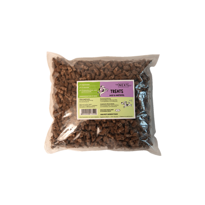Transparente Verpackung mit 500 g Treats von der Marke 'NEXT'. Die Treats haben eine unregelmäßige Form und sind braun. Auf der Vorderseite befindet sich ein Etikett mit Produktinformationen.