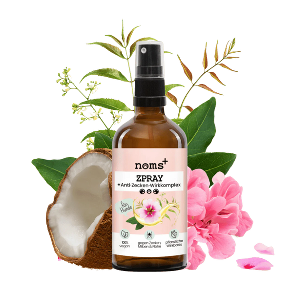Braune Sprühflasche mit Pumpkopf, beschriftet mit 'noms+ ZSPRAY Anti-Zecken-Wirkkomplex', umgeben von Pflanzen und Blüten.