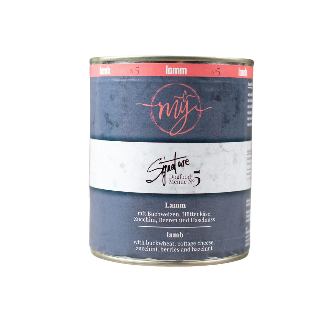 Dose Hundefutter mit blauem Etikett. Aufschrift: my Signature, Dogfood Menue No.5, Lamm und Zutaten wie Buchweizen, Zucchini, Hüttenkäse, Cranberry, Heidelbeeren, Haselnuss