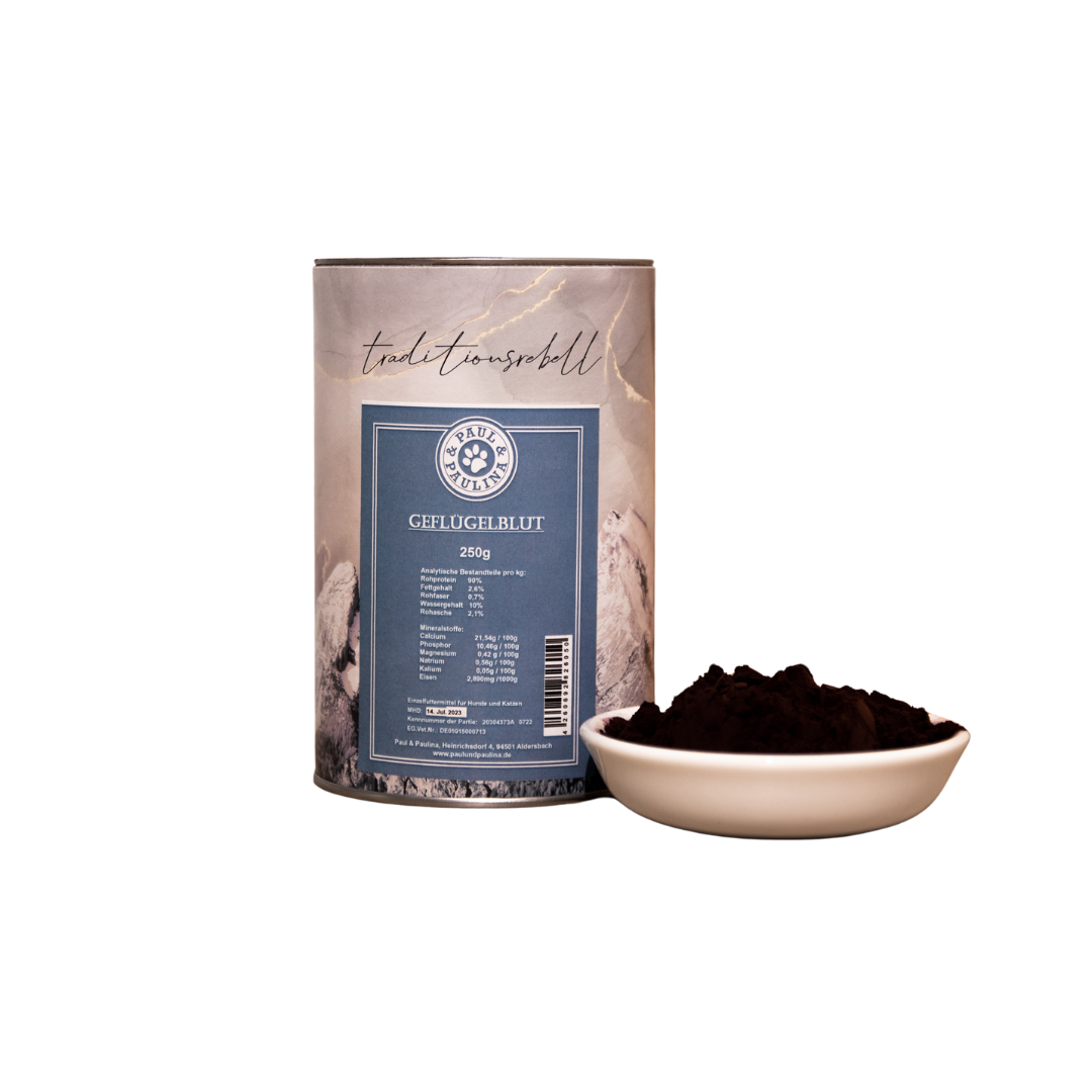 Dosenverpackung mit der Aufschrift 'Paul & Pauline Geflügelblut 250g' neben einer weißen Schale mit dunkelbraunem Pulver.