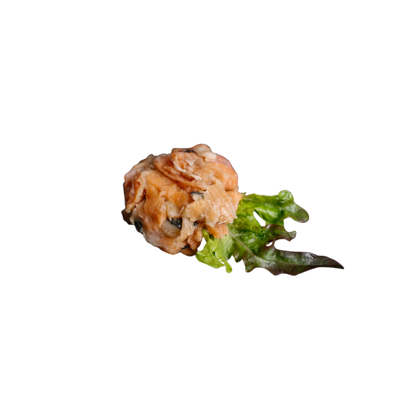 Stück roher Lachs auf weißem Untergrund mit grünem Salatblatt