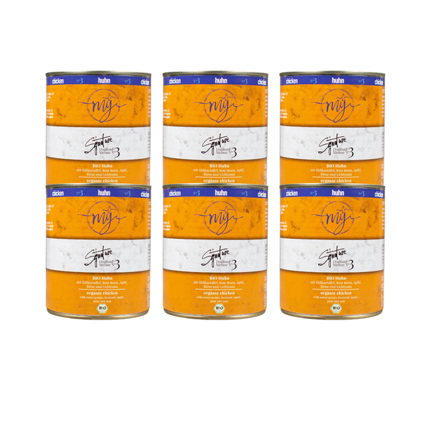 Sechs Dosen Hundefutter mit gelben Etikett. Aufschrift: my Signature, Dogfood Menue No. 3, BIO Huhn und Zutaten wie Süßkartoffel, Rote Beete, Äpfel, Birne.