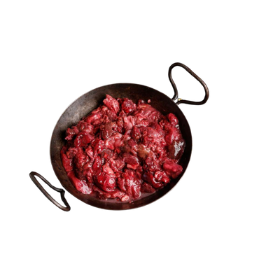 Eisenpfanne mit rohem, grob zerkleinertem rotem Fleisch