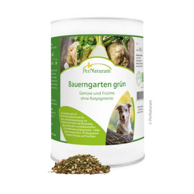 Weißer Behälter mit grünem Etikett der Marke PerNaturam, Produktname 'Bauerngarten grün', mit Text "Gemüse und Früchte ohne Rotpigmente" und einem Bild eines braun und weißen Hundes, davor lose Kräutermischung.
