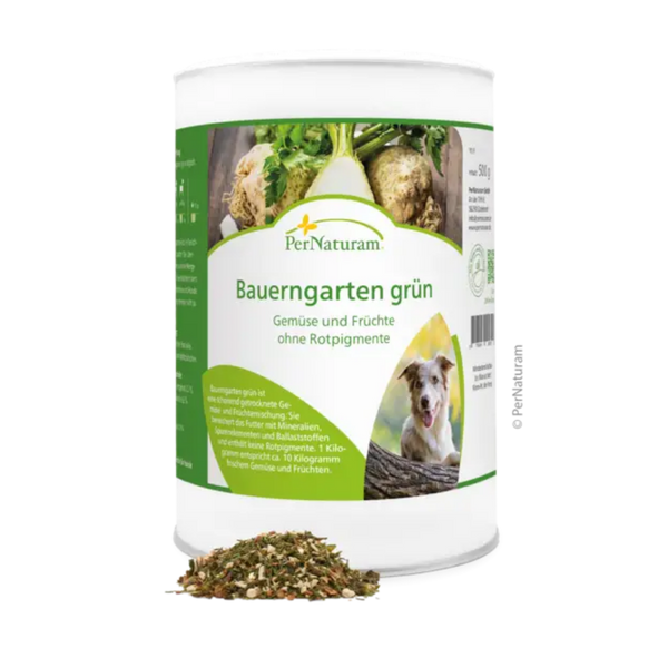 Weißer Behälter mit grünem Etikett der Marke PerNaturam, Produktname 'Bauerngarten grün', mit Text "Gemüse und Früchte ohne Rotpigmente" und einem Bild eines braun und weißen Hundes, davor lose Kräutermischung.