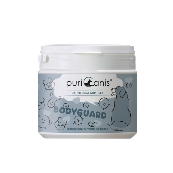 Weißer Behälter mit Aufschrift 'puriCanis DARMFLORA KOMPLEX BODYGUARD Ergänzungsfuttermittel für Hunde' und Zeichnung eines sitzenden Hundes sowie verschiedener lachender und lächelnder Gesichter und Sterne