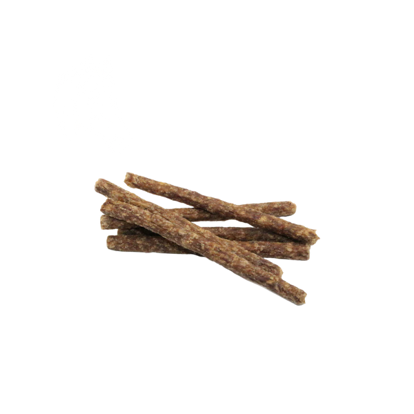 Mehrere getrocknete, längliche Fleischministicks ohne Verpackung auf weißem Hintergrund