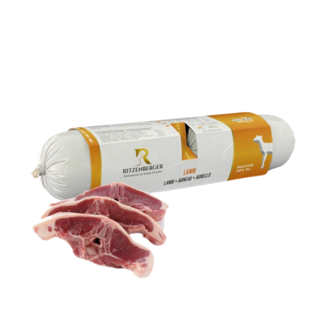 Verpackte Fleischrolle mit Lamm von Ritzenberger, daneben rohe Lammfleischstücke