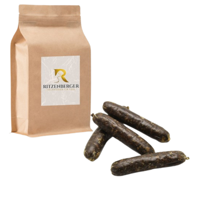 Braune Papiertüte mit Aufkleber 'Ritzenberger' neben vier dunkelbraunen, länglichen Würsten.