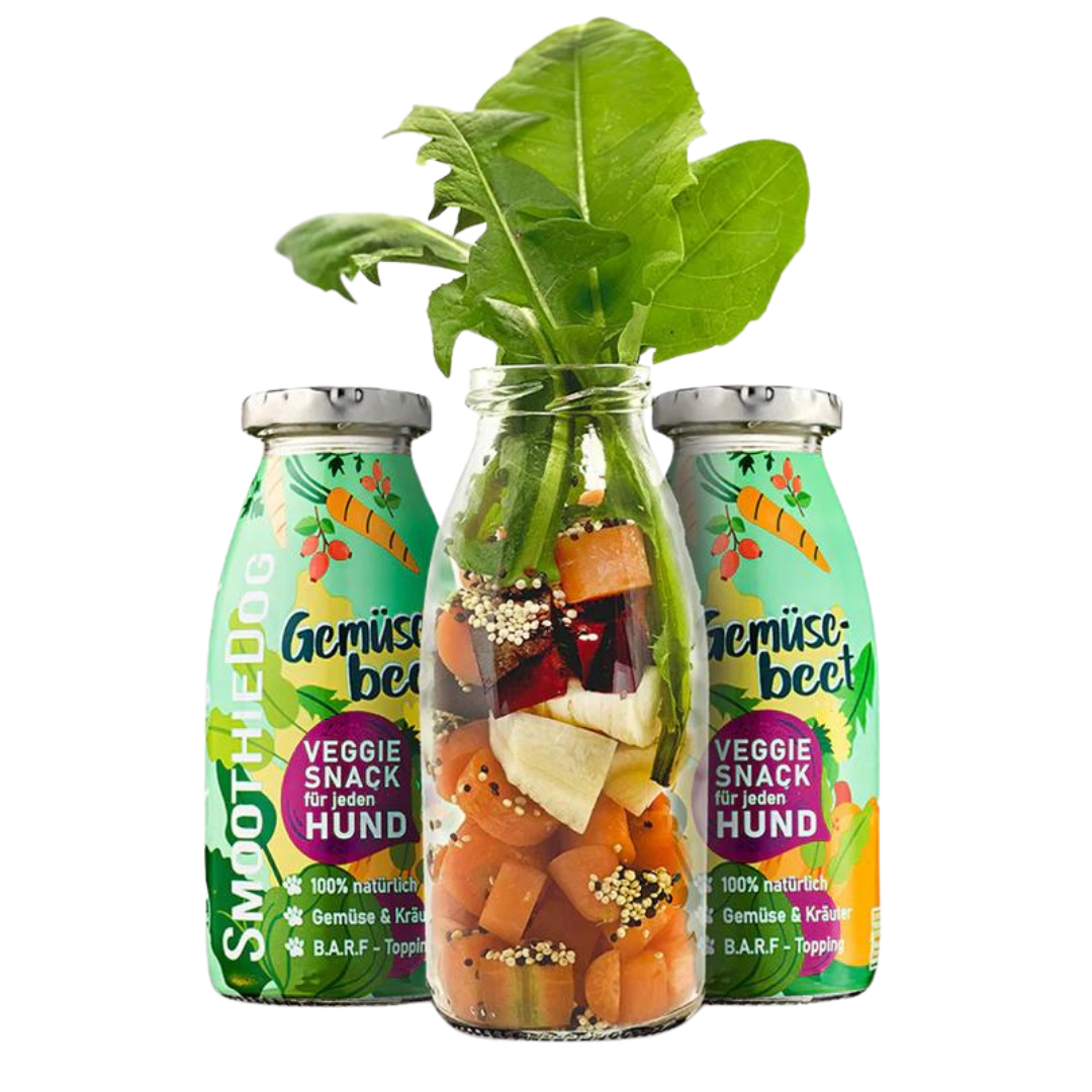 Zwei Flaschen SmoothieDog Trinkpause mit Gemüsebeet, davor Glasflasche mit geschnittenem, Gemüse und Kräutern.