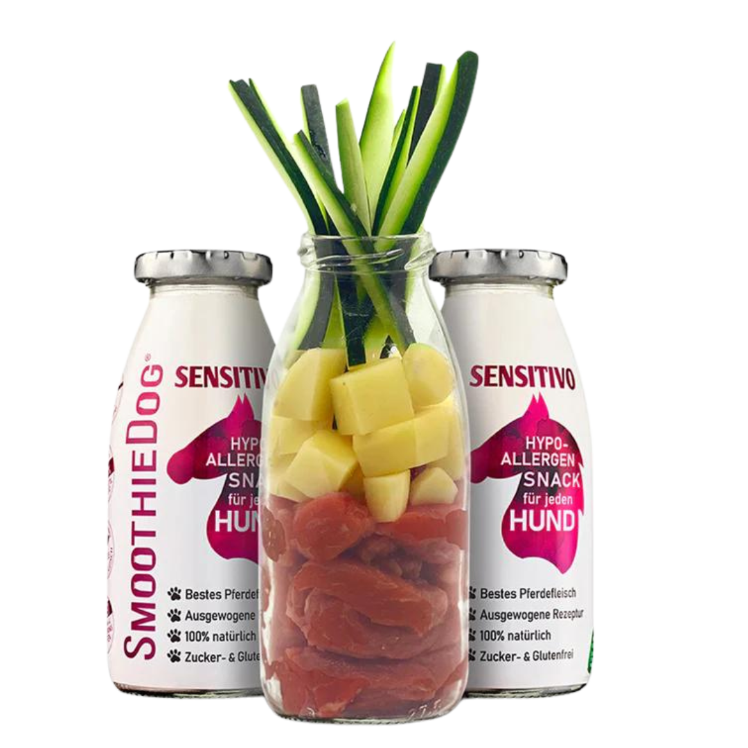 Zwei Flaschen SmoothieDog Trinkpause mit Pferd, Obst und Gemüse, davor Glasflasche mit geschnittenem Obst und Gemüse