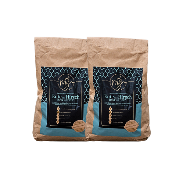 Zwei braune Papiertüten mit blauen Etiketten, beschriftet mit 'mysignature Ente und Hirsch Duck and Deer', jeweils mit goldfarbenem Siegelaufkleber.