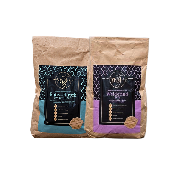 Zwei braune Papiertüten mit blau und violett Etiketten, beschriftet mit 'mysignature Ente und Hirsch Duck and Deer', Weiderind,Beef jeweils mit goldfarbenem Siegelaufkleber