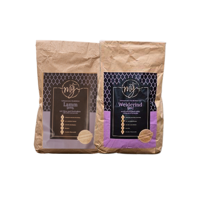 Zwei braune Papiertüten mit violetten Etiketten, beschriftet mit 'mysignature Lamm, Lamp und Weiderind,Beef jeweils mit goldfarbenem Siegelaufkleber