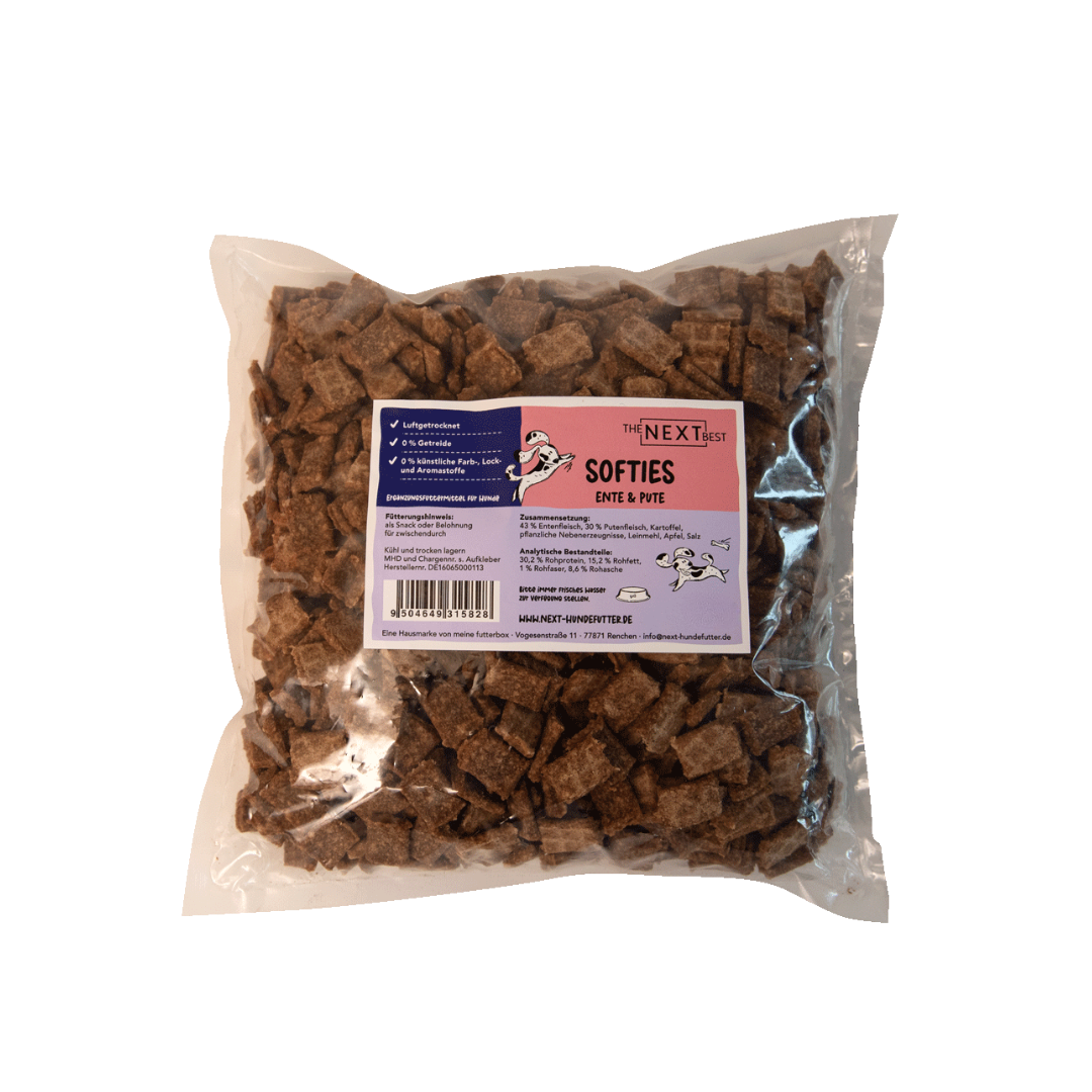 Transparente Verpackung mit 500 g Softies von der Marke 'NEXT'. Die Softies haben eine unregelmäßige Form und sind braun. Auf der Vorderseite befindet sich ein Etikett mit Produktinformationen.