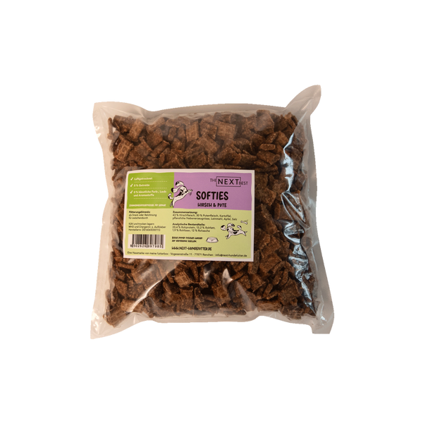 Transparente Verpackung mit 500 g Softies von der Marke 'NEXT'. Die Softies haben eine unregelmäßige Form und sind braun. Auf der Vorderseite befindet sich ein Etikett mit Produktinformationen.