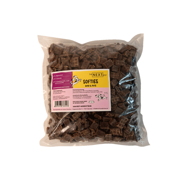 Transparente Verpackung mit 500 g Softies von der Marke 'NEXT'. Die Softies haben eine unregelmäßige Form und sind braun. Auf der Vorderseite befindet sich ein Etikett mit Produktinformationen.