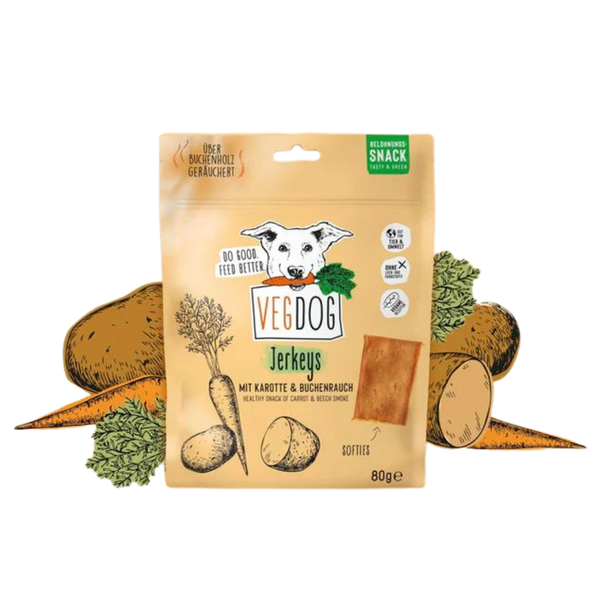 Beige Verpackung von Vegdog Jerkeys mit Hundekopf-Logo, Text 'Mit Karotte & Buchenrauch', Abbildung von Karotten und Kartoffeln, 80 Gramm.
